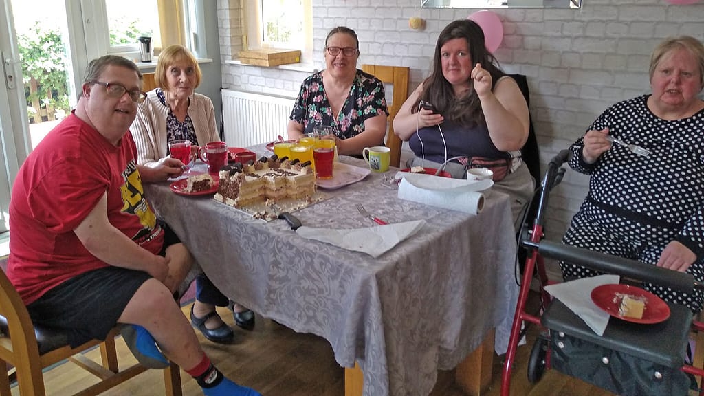Residents and visitors at Birch House enjoying cake