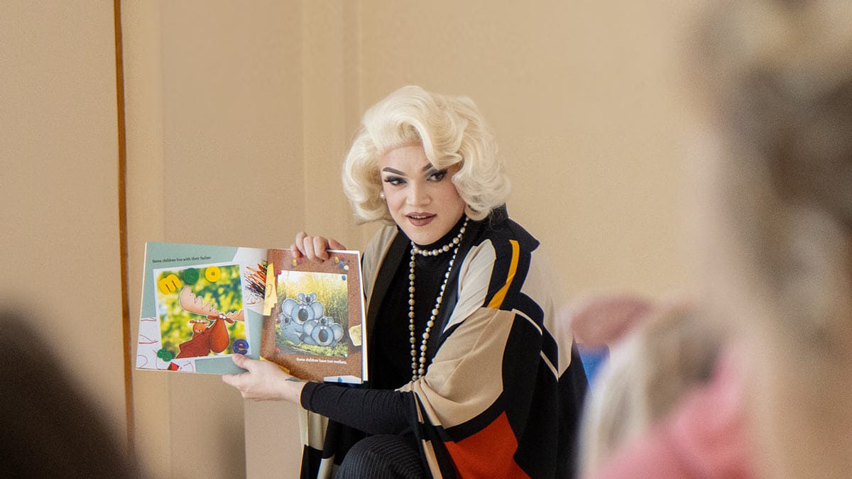 Sylvia reads a children's book to a family audience