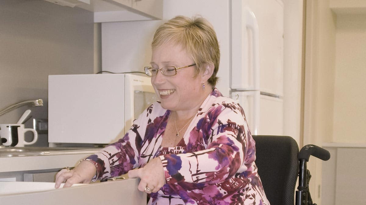 Smiling woman in wheelchair in the kitchen