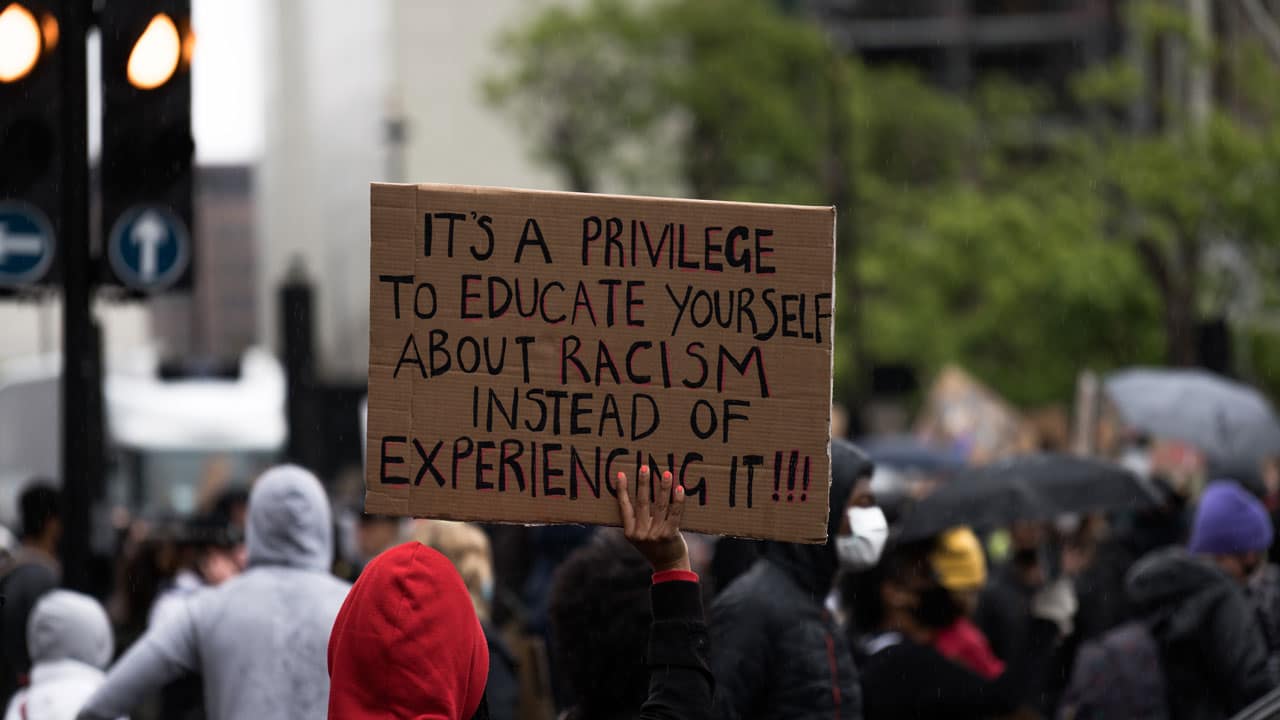 Anti racism placard stating: It's a privilege to educate yourself about racism instead of experiencing it!