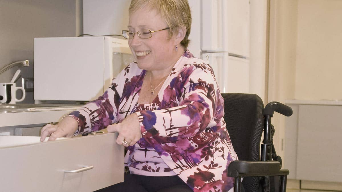 Smiling woman in a wheelchair in the kitchen