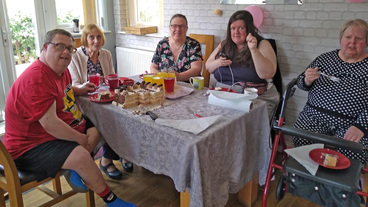 Residents and visitors at Birch House enjoying cake